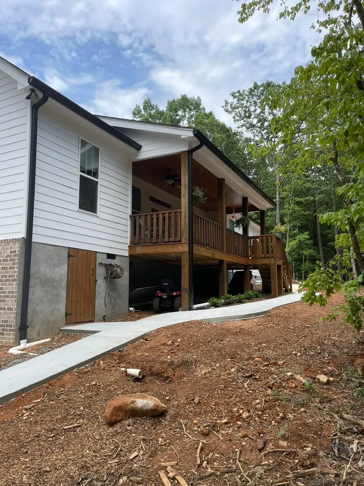 A white house with a large porch and a walkway leading to it.