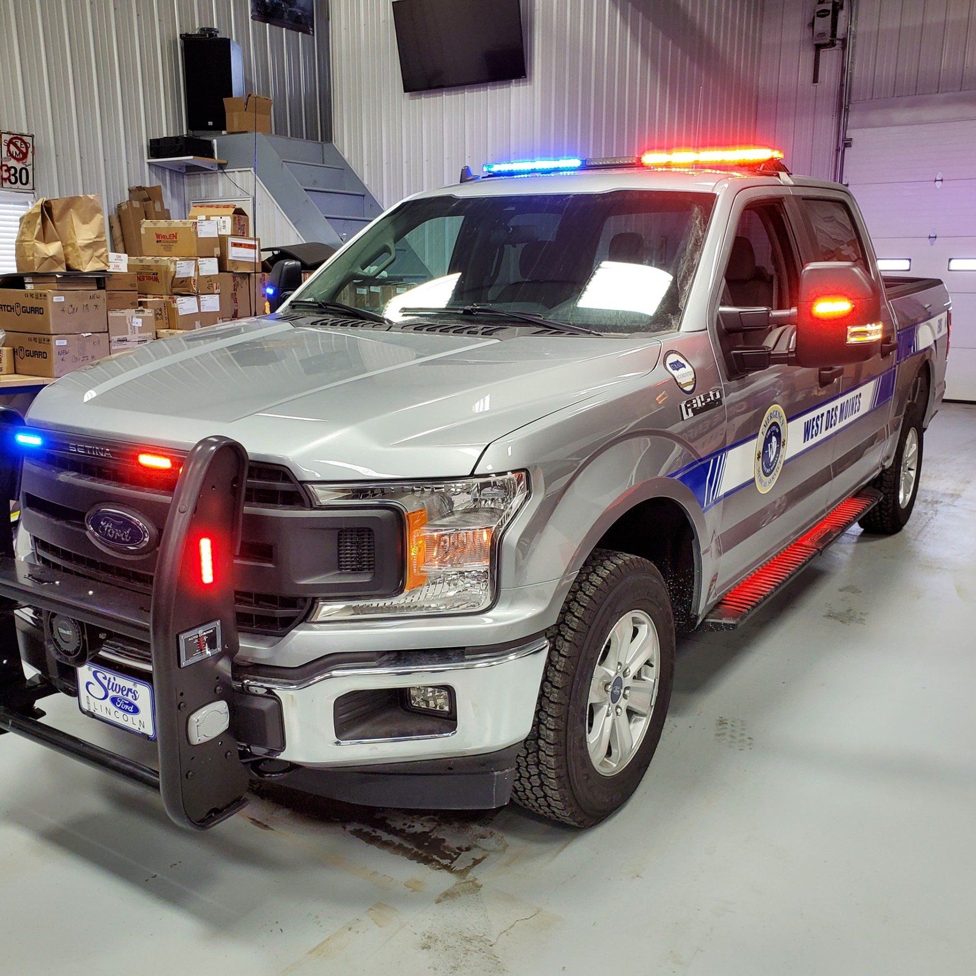 A police truck is parked in a garage with lights on.