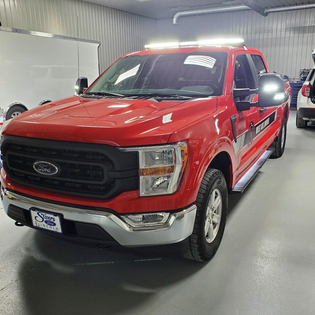 A red ford truck is parked in a garage.