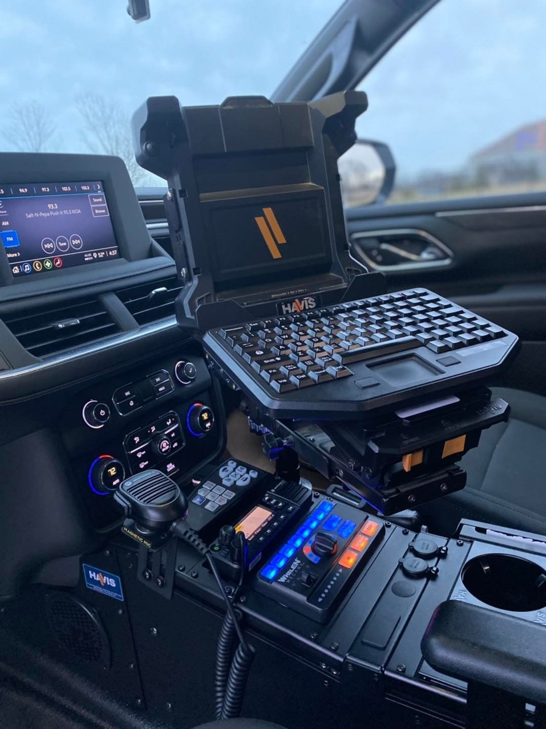 A laptop is sitting on top of a dashboard in a car.