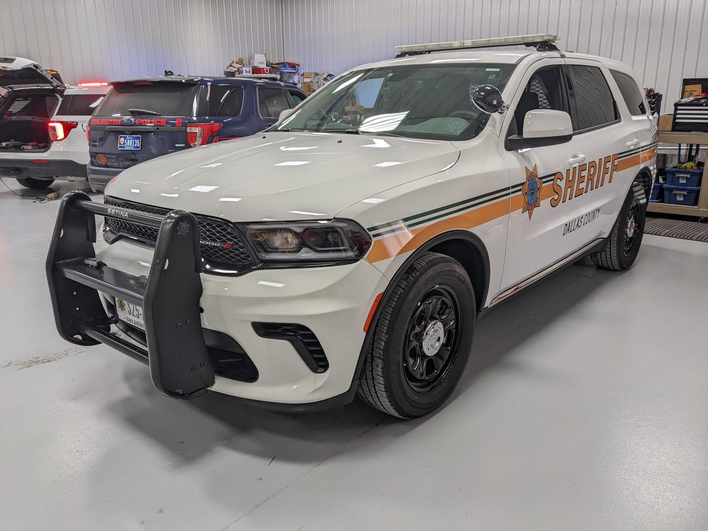 A white sheriff 's car is parked in a garage.