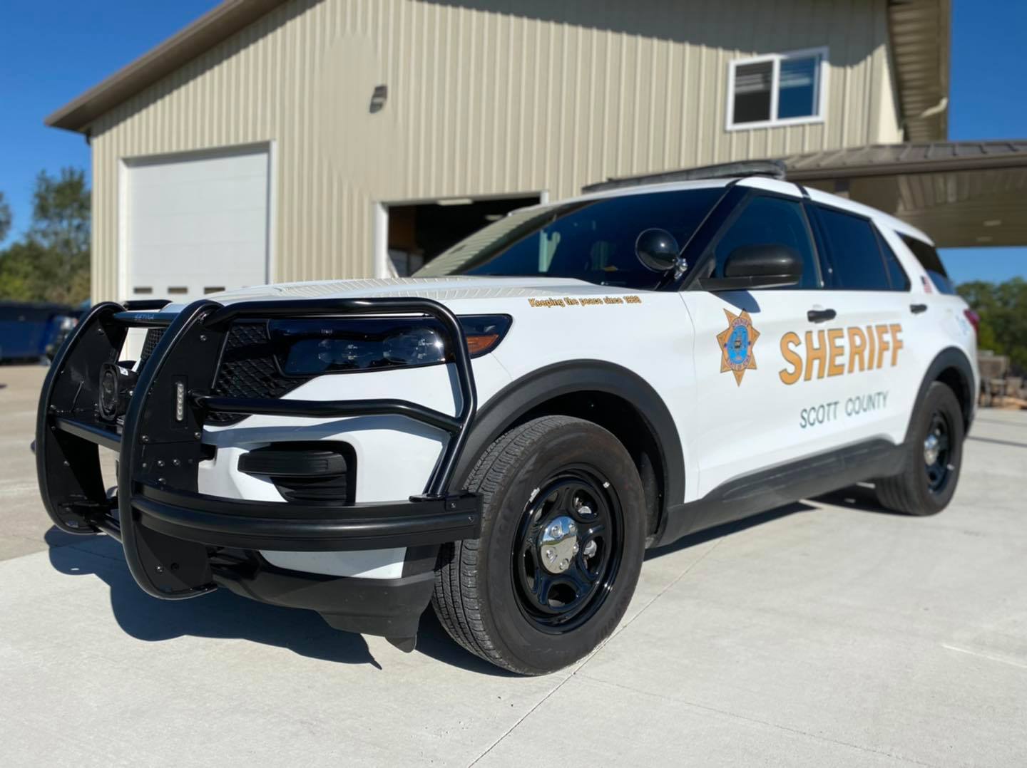 A sheriff 's car is parked in front of a building.
