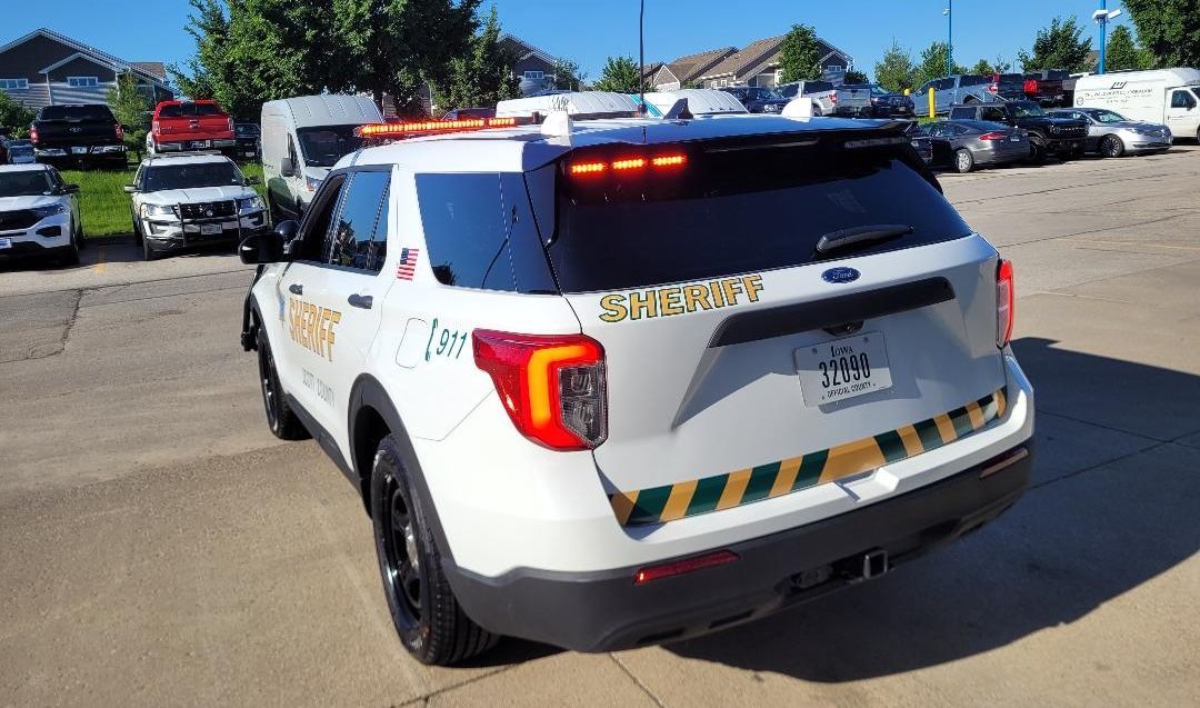A white police car is parked in a parking lot.