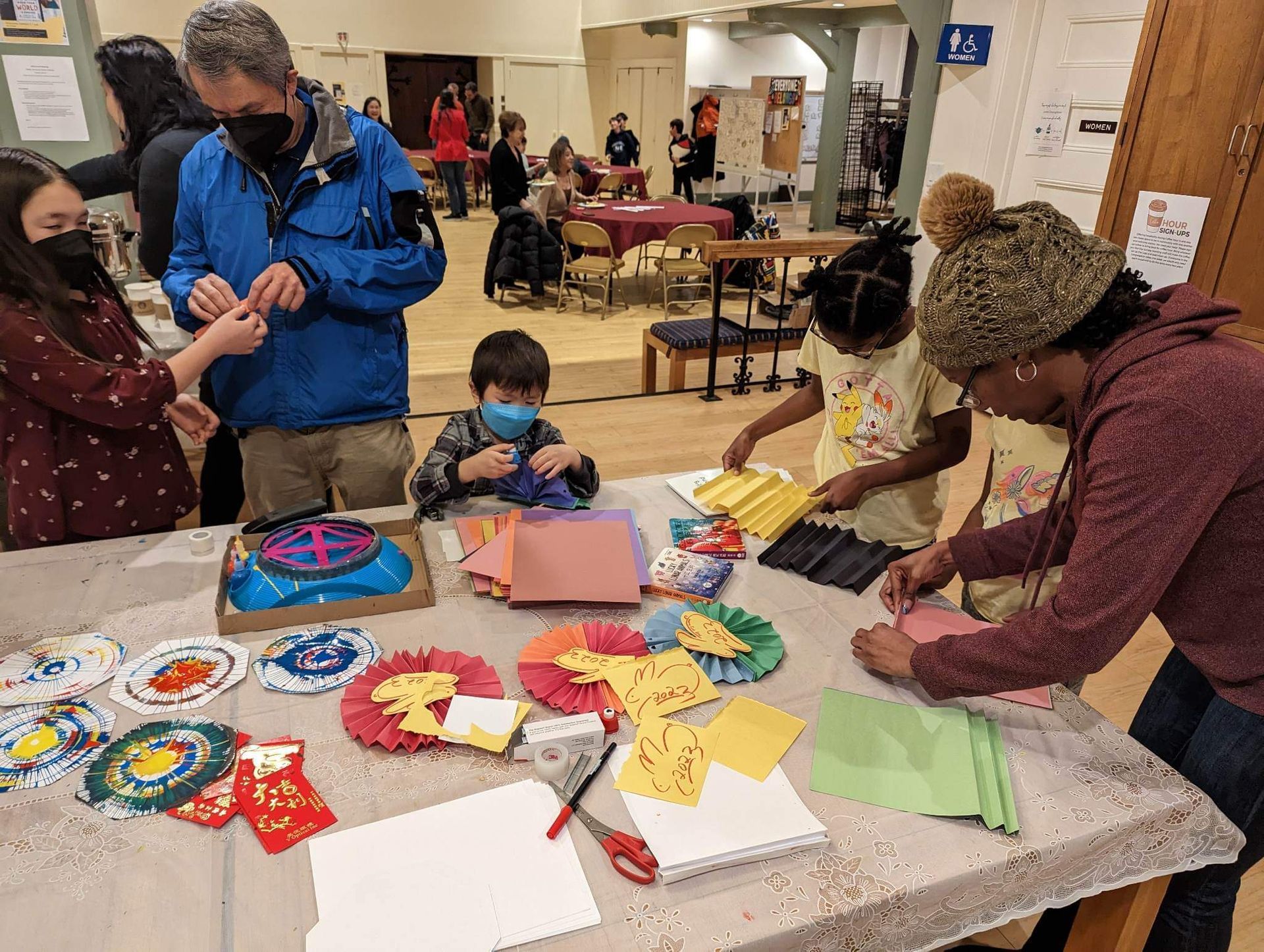 A group of people are sitting around a table making crafts.