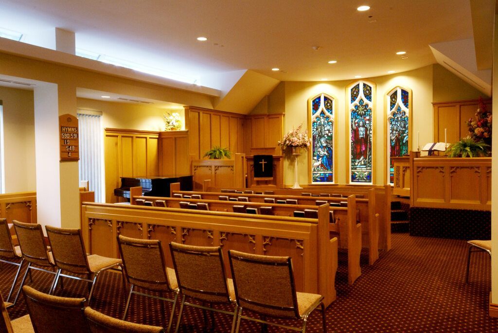 Church interior with pews, stained glass windows, and a piano.