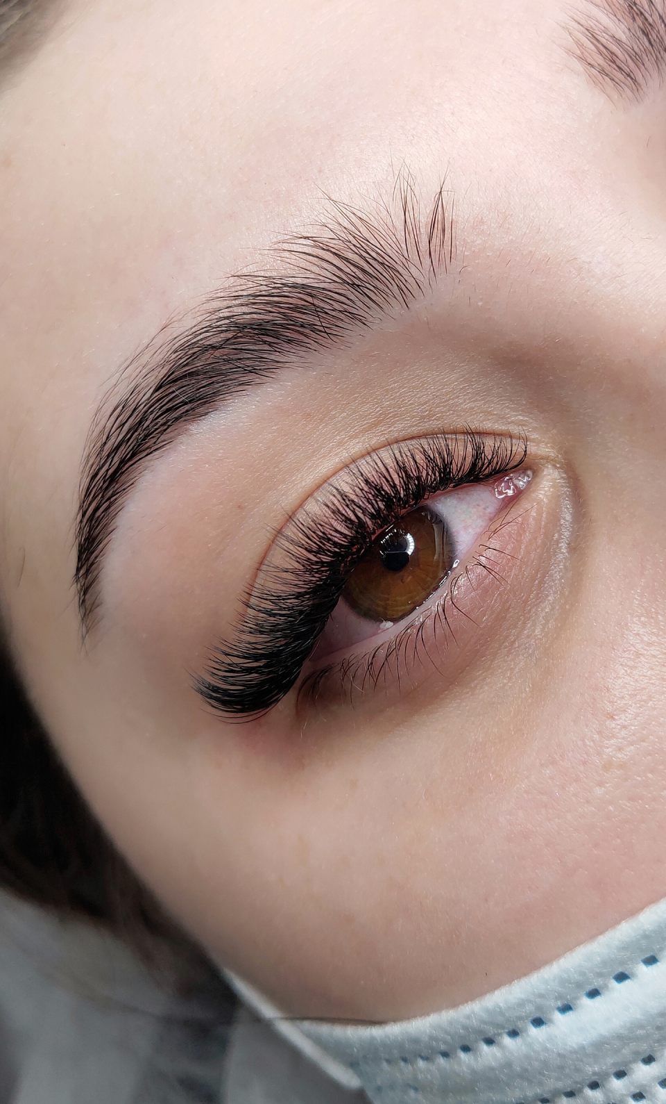 Lash extensions in beauty salon macro eye top view
