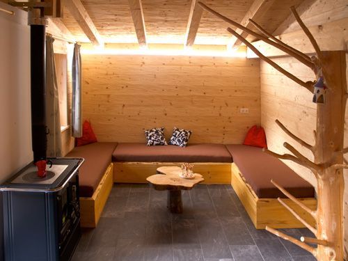 Ein gemütliches Holzzimmer mit U-förmiger, brauner Polstersitzgruppe