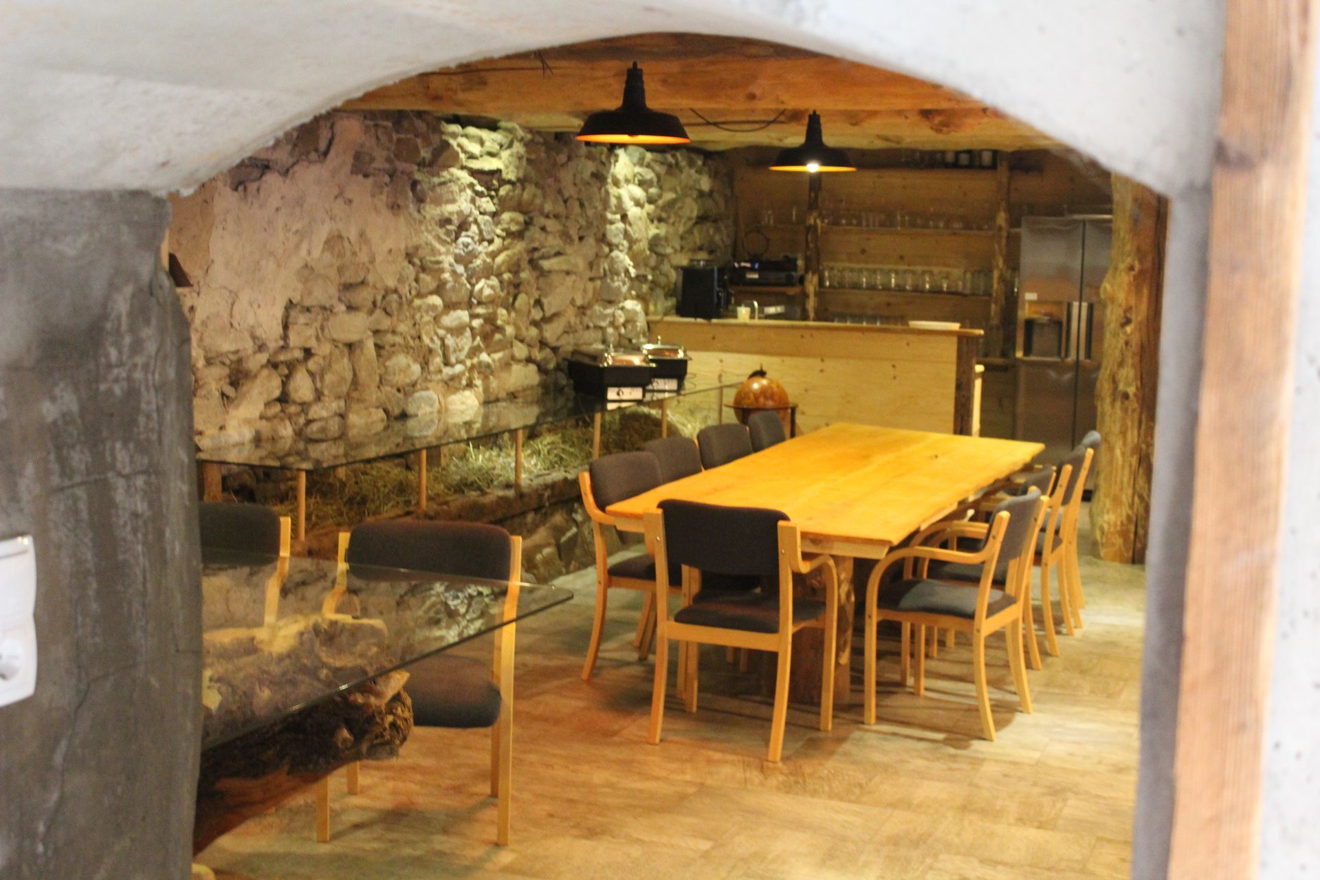 Ein rustikaler, von Steinmauern umgebener Raum mit einem hölzernen Esstisch