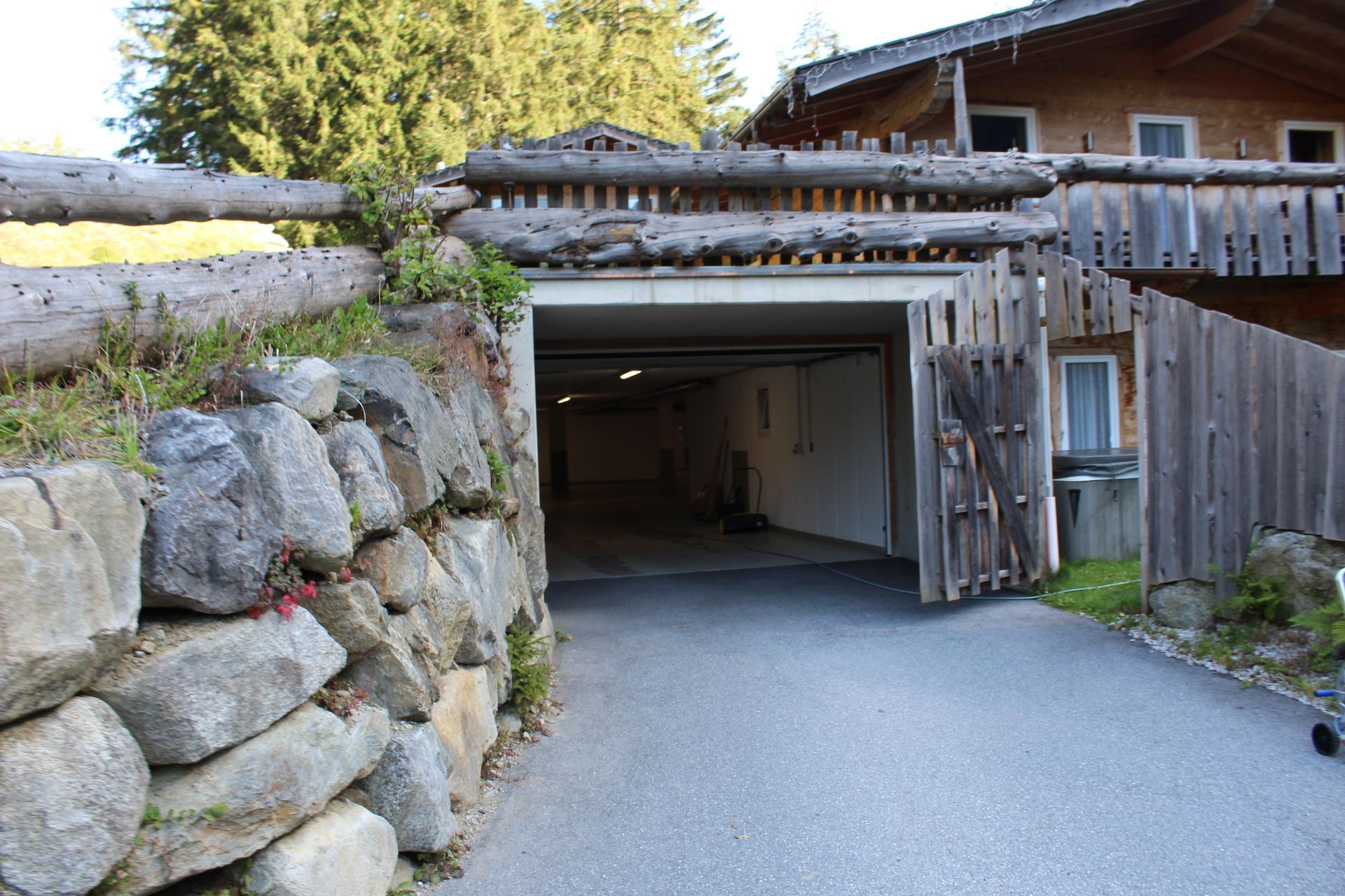Eine gepflasterte Auffahrt führt in eine dunkle Garage