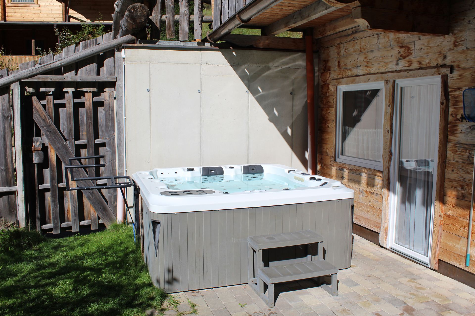 Auf einer gepflasterten Terrasse neben einer rustikalen Holzhütte 