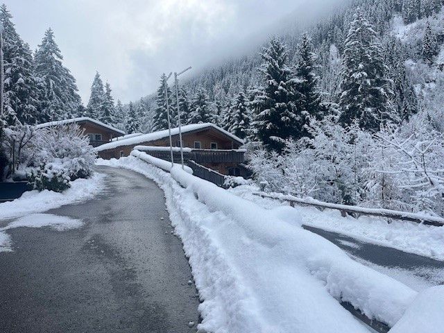 Eine schneebedeckte Straße führt zu Holzhäusern
