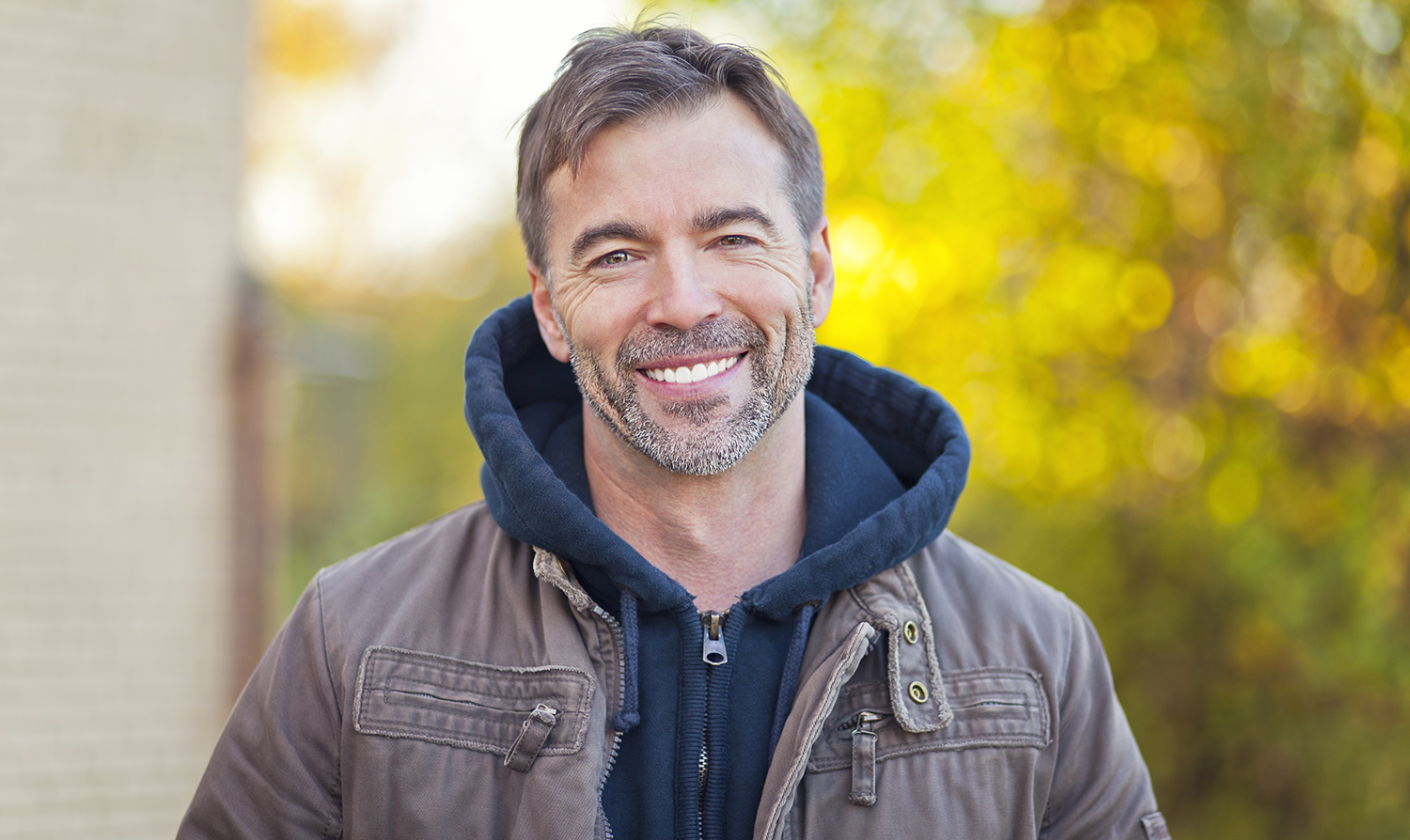 man stood outside with a bright white smile