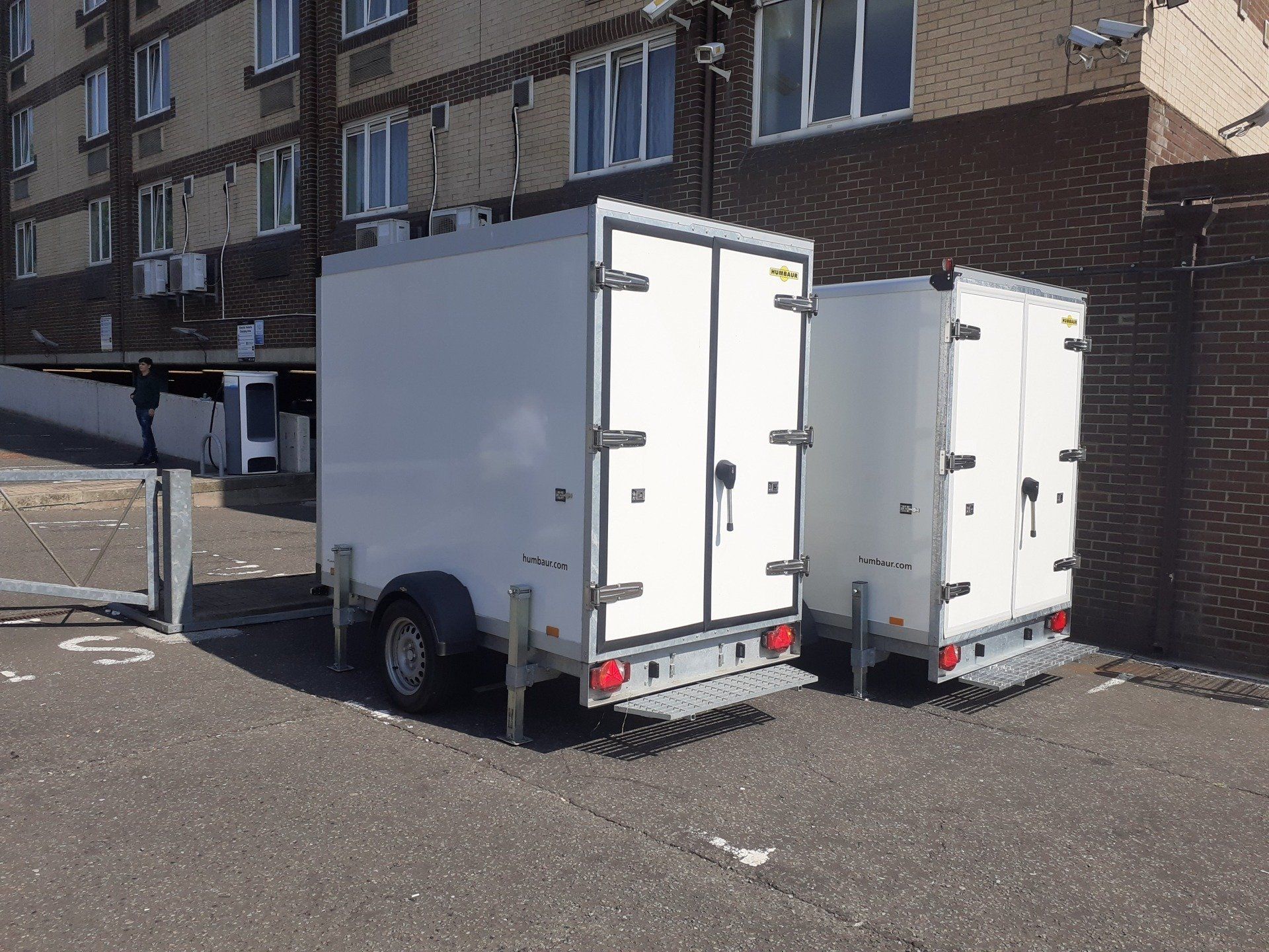 two refrigerated trailers parked outside a hotel