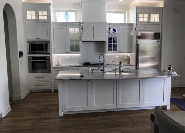 A kitchen with white cabinets and stainless steel appliances
