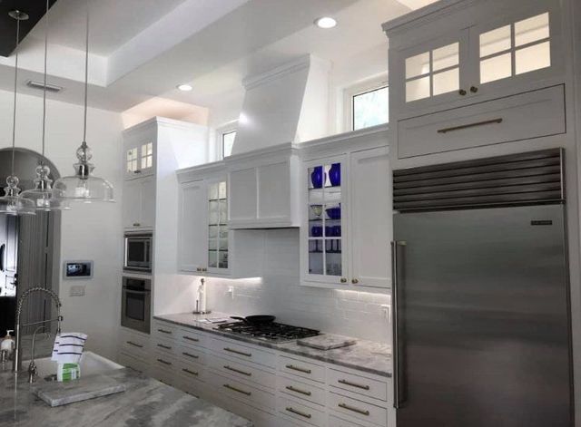 A kitchen with white cabinets and stainless steel appliances