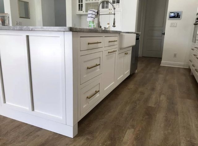 A kitchen with white cabinets and a sink