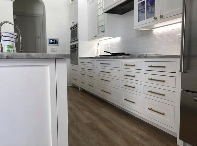 A kitchen with white cabinets and stainless steel appliances.