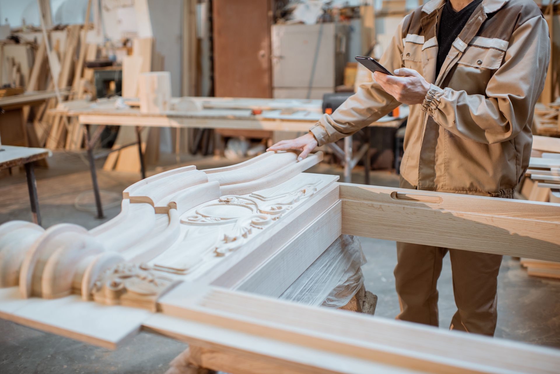 A man is working on a piece of wood in a workshop.