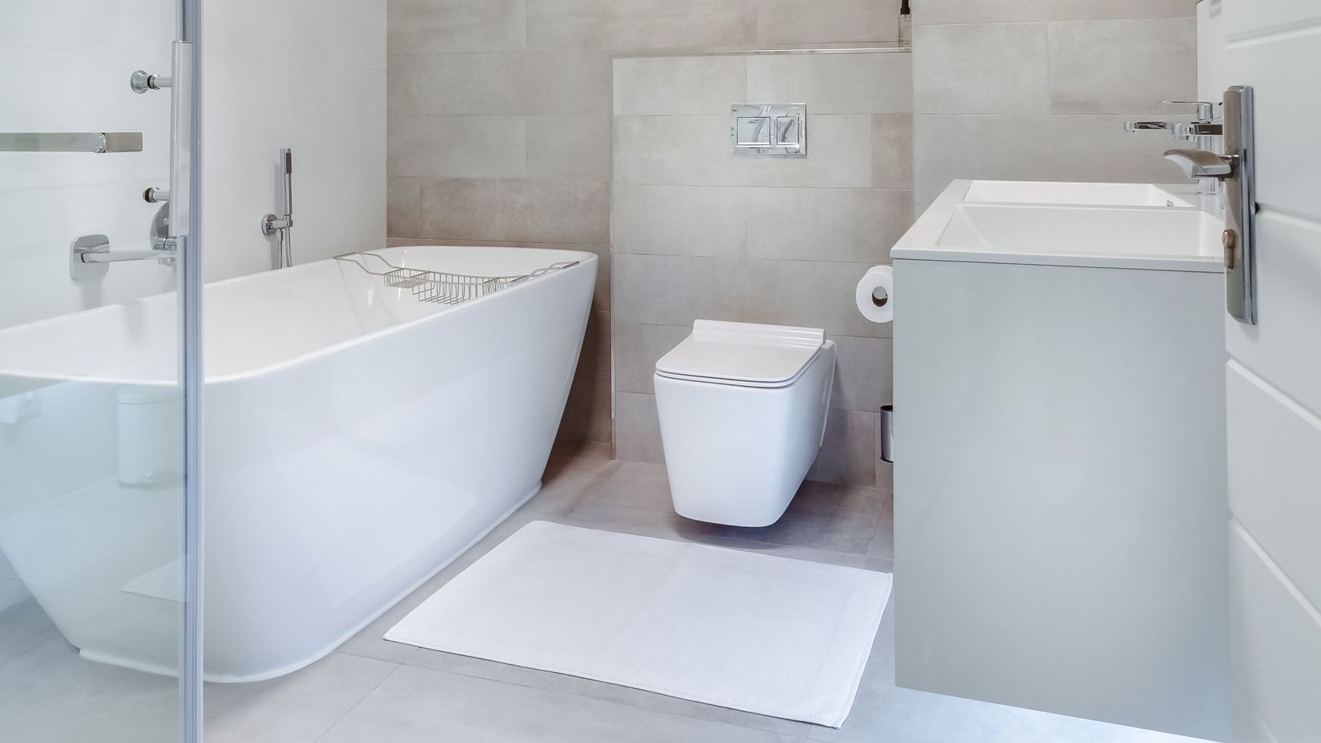 A bathroom with a bathtub , toilet , sink and shower.