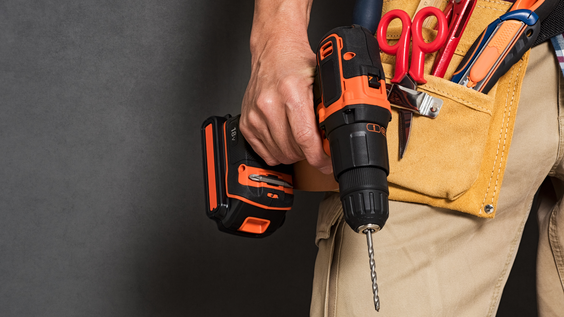A green drill next to a bunch of drill bits