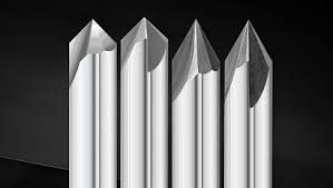 A black and white photo of four white sticks on a black surface.