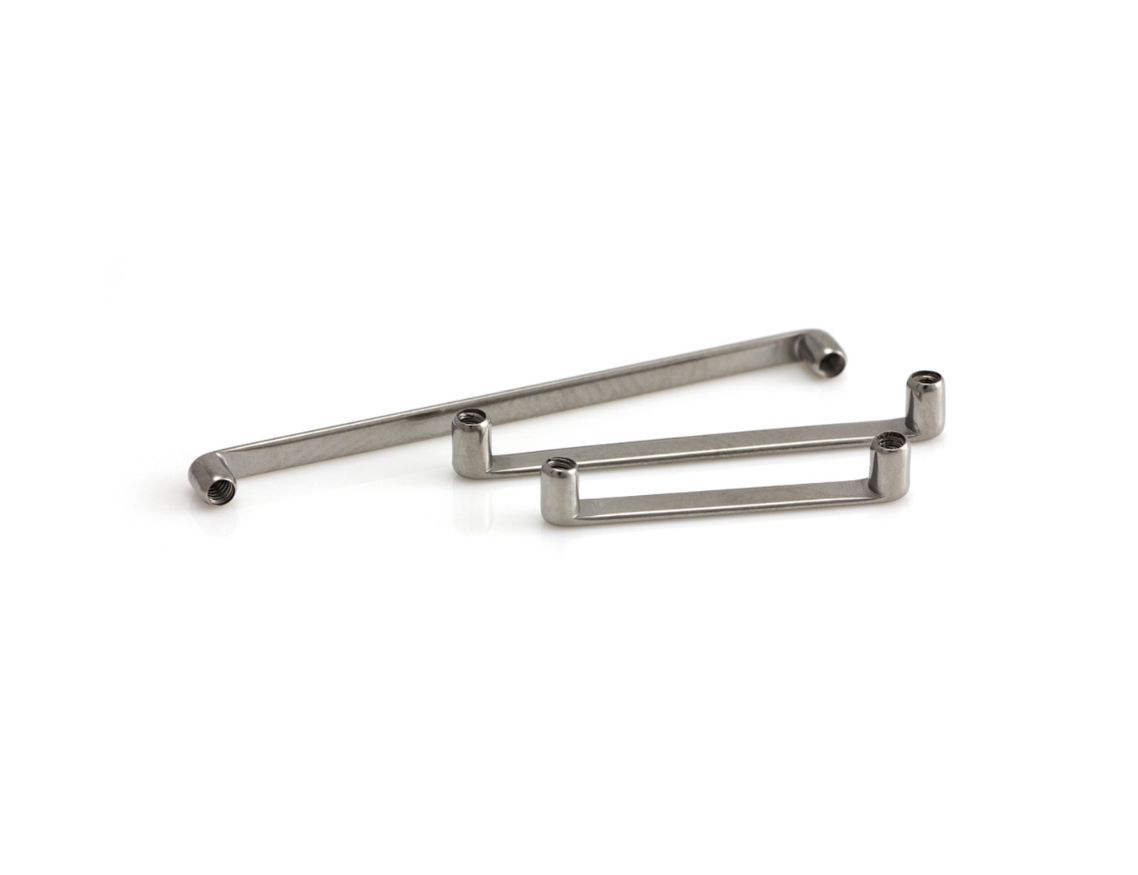 Two pieces of metal are sitting on top of each other on a white surface.