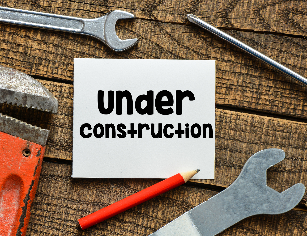 A wooden table with tools and a sign that says under construction