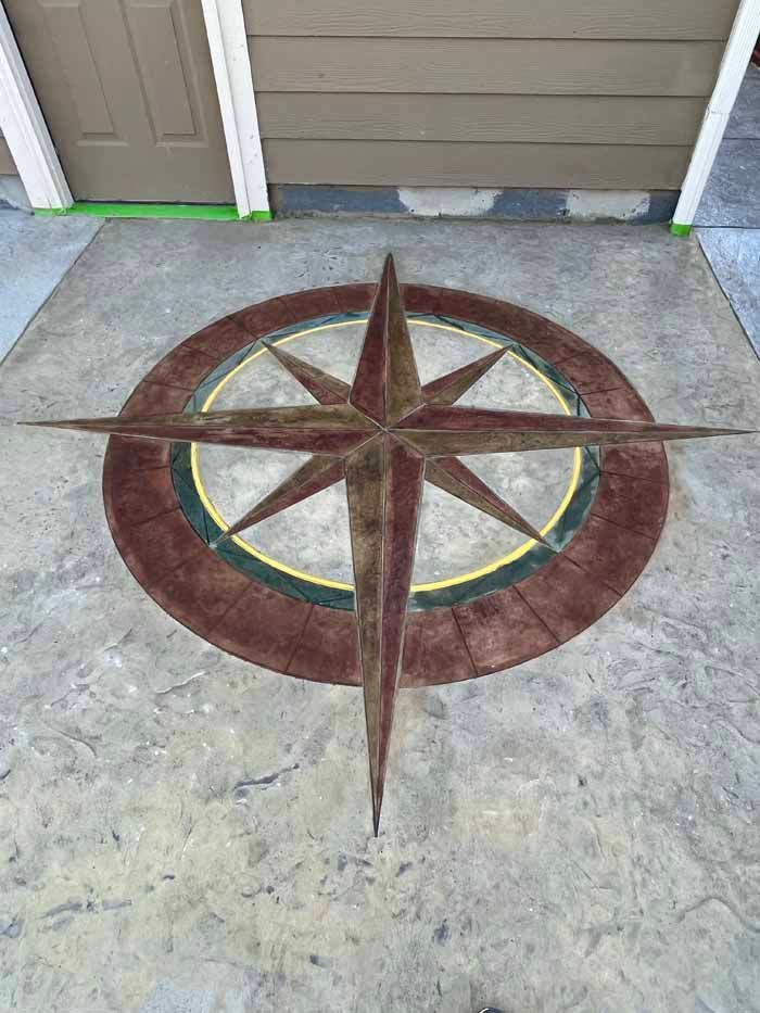 Concrete patio with a brown compass rose design.