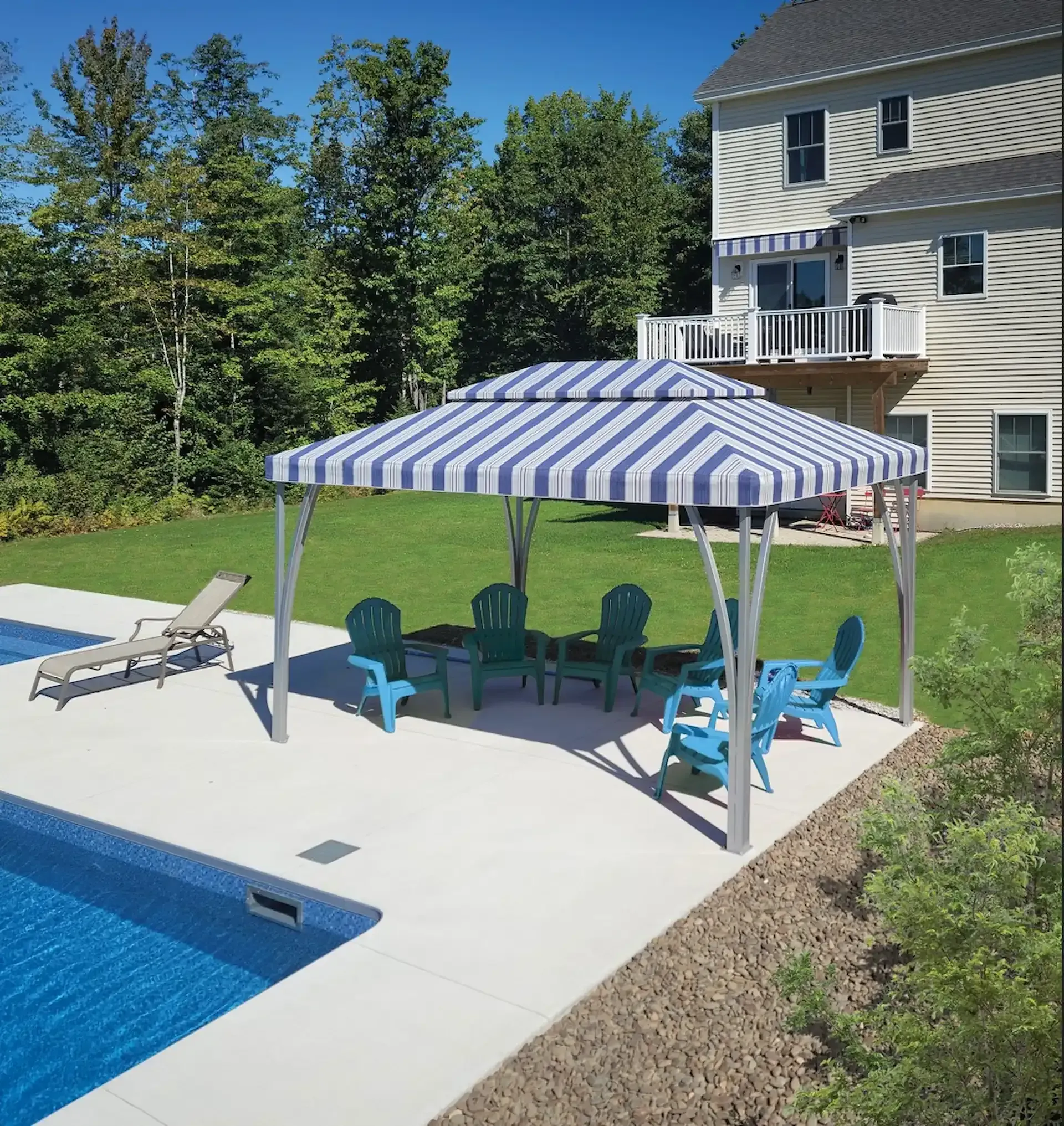 A blue-and-white striped gazebo on a pool deck with several teal Adirondack chairs and a lounge chair nearby.