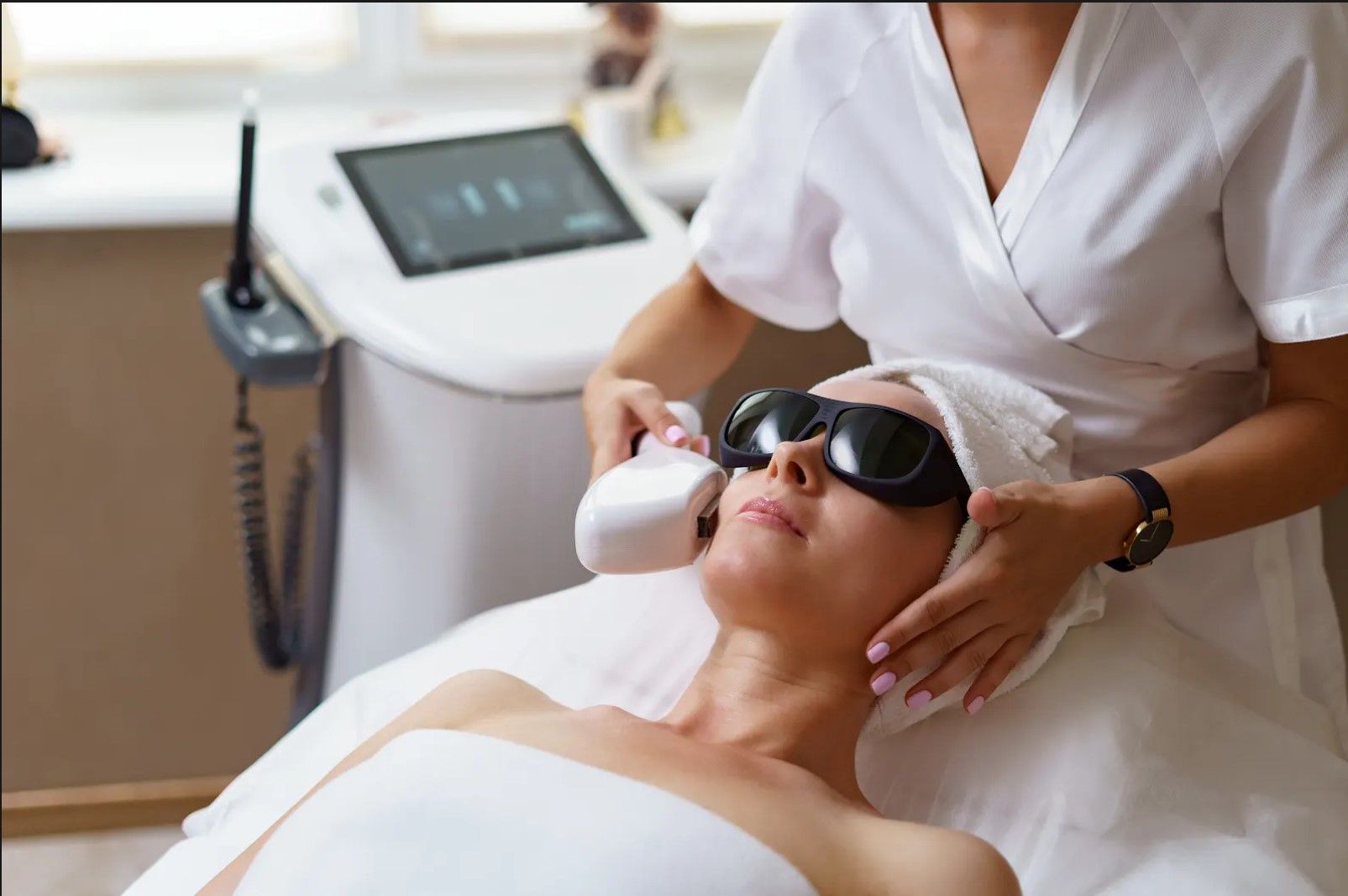 A woman is getting a laser treatment on her face.