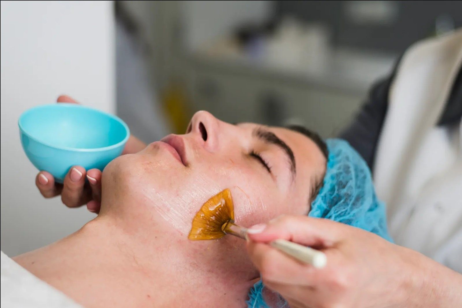 A man is getting a facial treatment at a beauty salon.