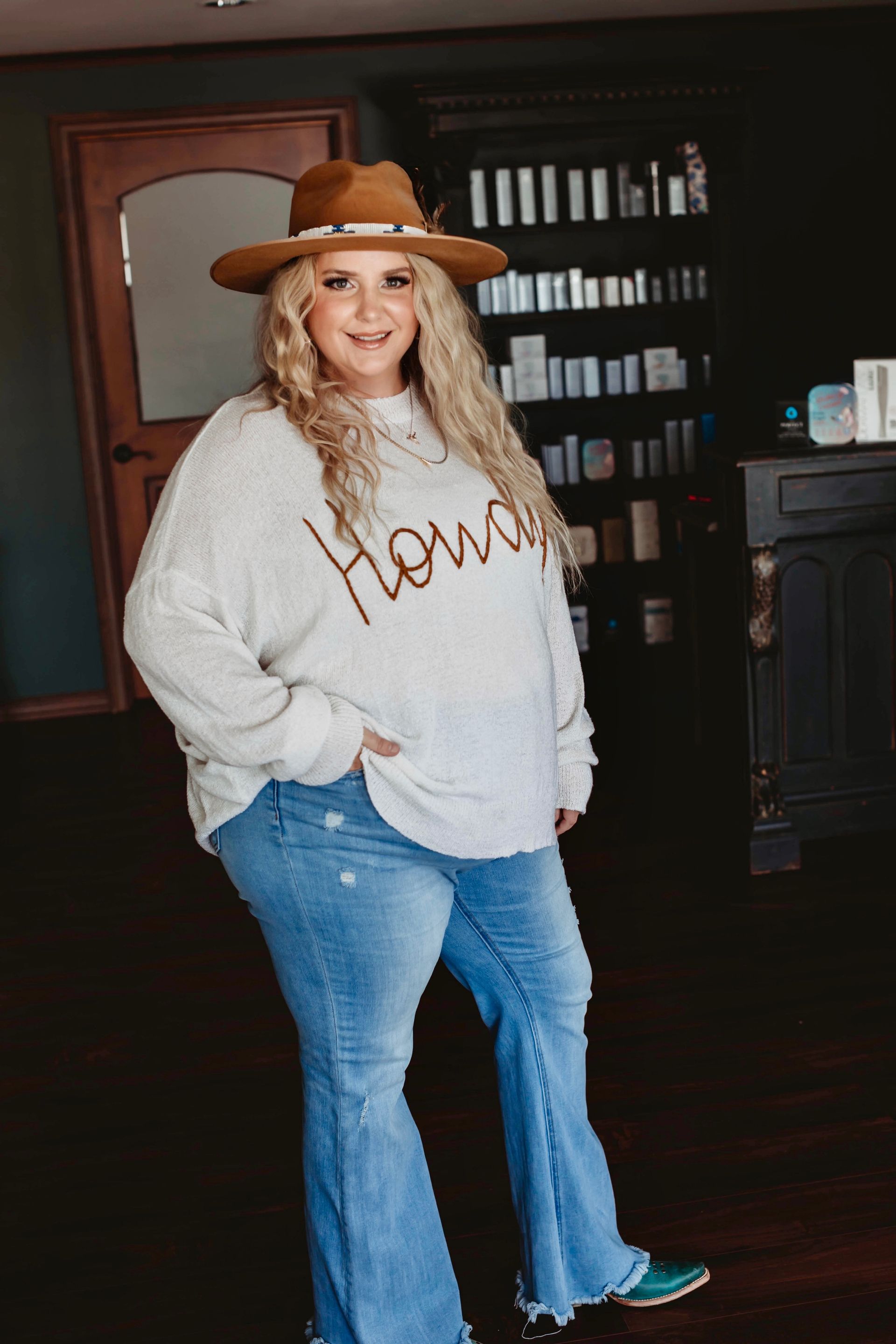 A woman in a black dress and green boots is sitting in a chair.