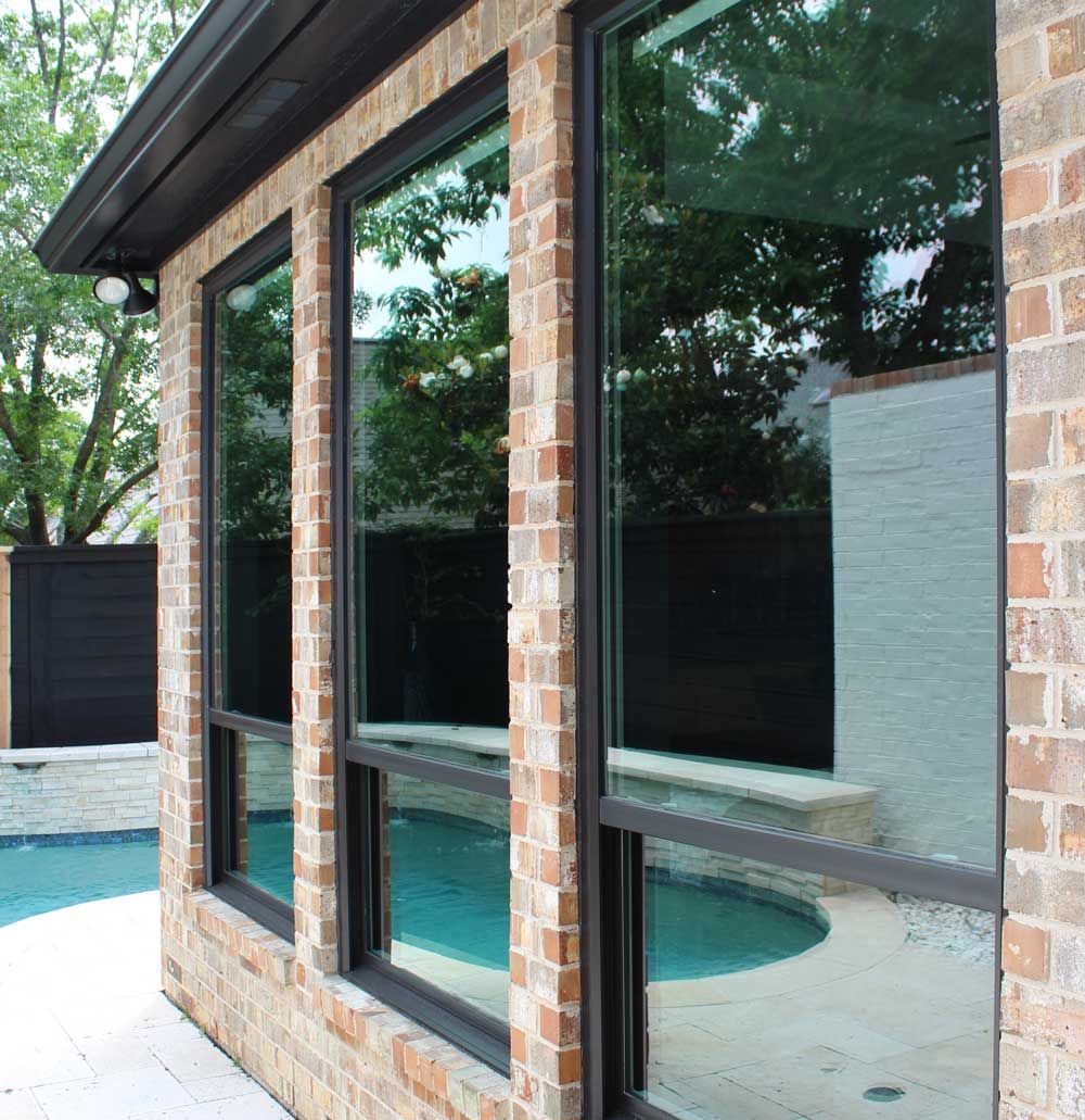 A brick building with a swimming pool in the background