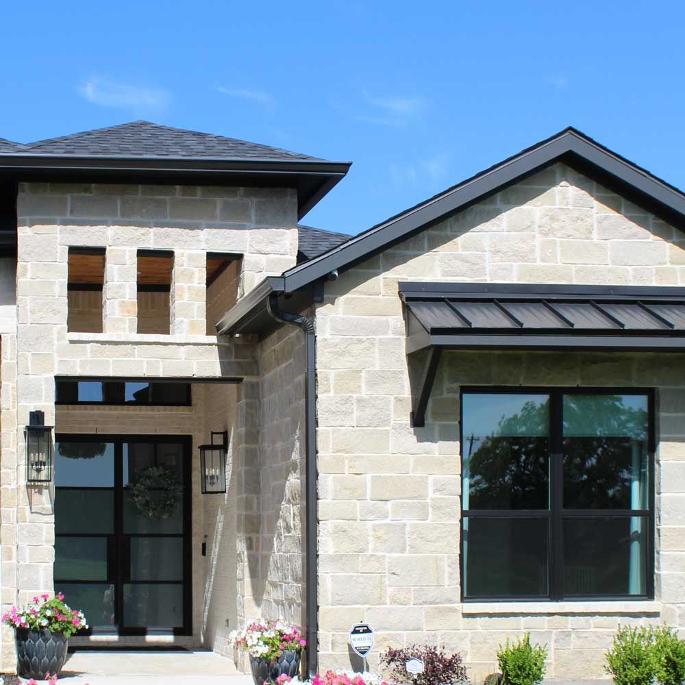 The front of a brick house with a black roof