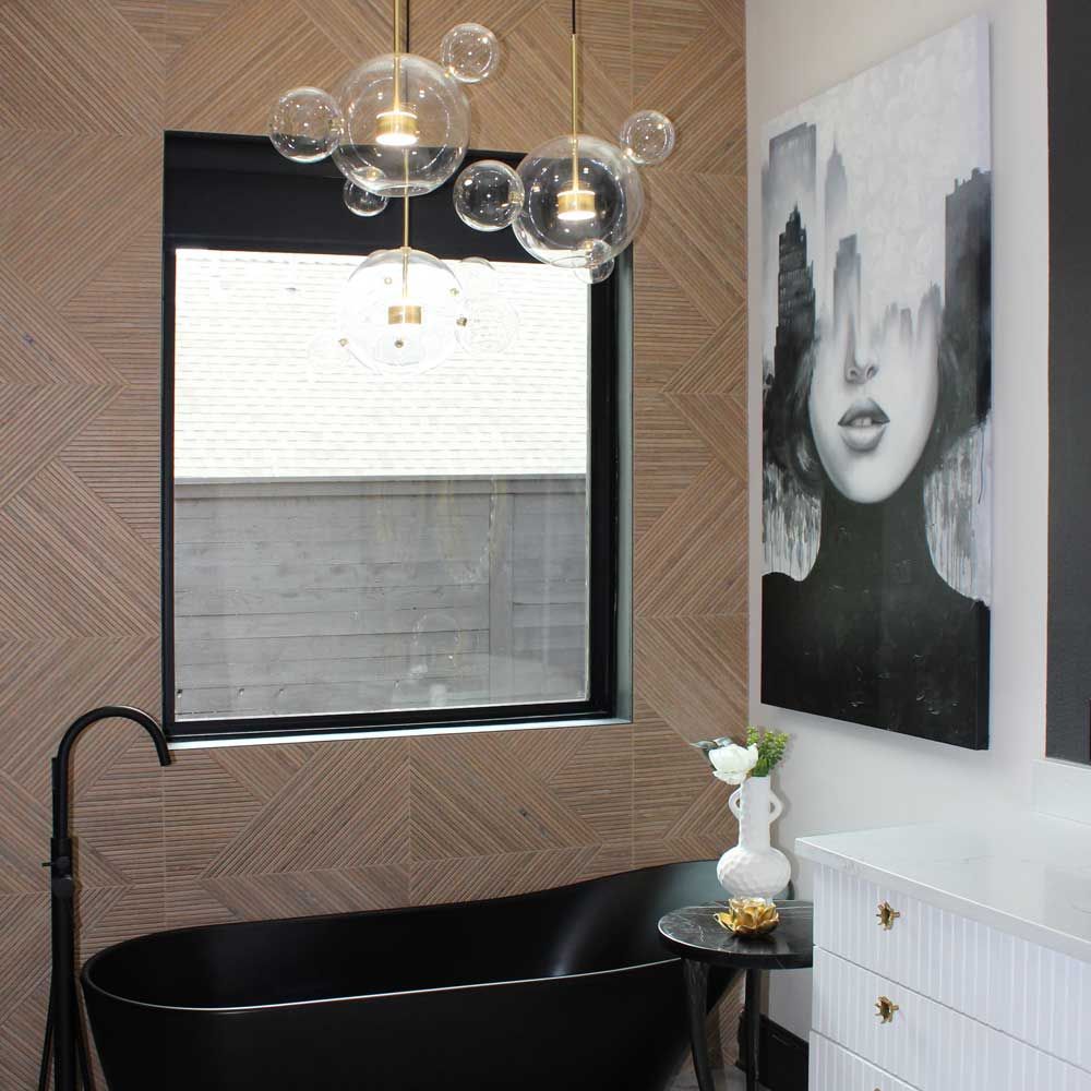 A bathroom with a black tub and a painting on the wall