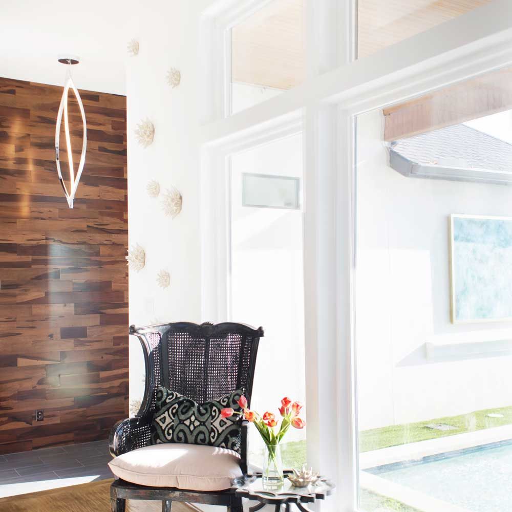 A living room with a chair and a table with flowers on it