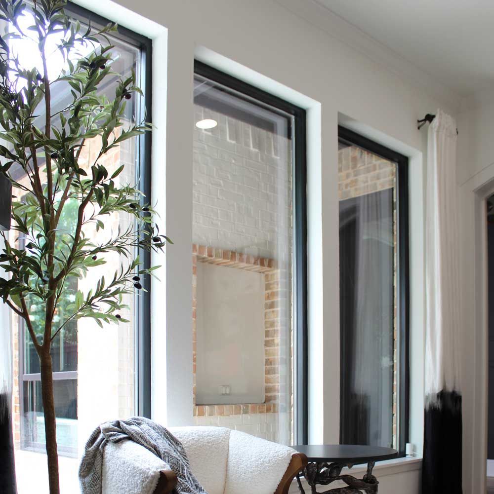 A living room with lots of windows and a chair