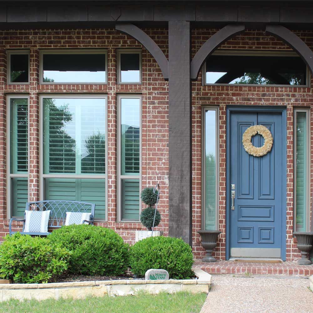 A brick house with a blue door and a wreath on it