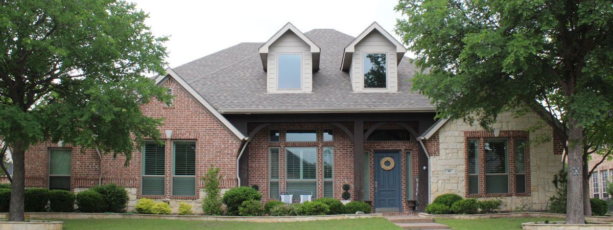 A large brick house with a blue door and windows