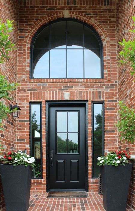 A brick building with a black door and a large window