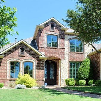 A large brick house with a lot of casement windows and a new door replacement