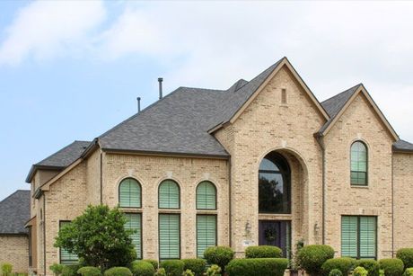 A large brick house with arched windows and a gray roof