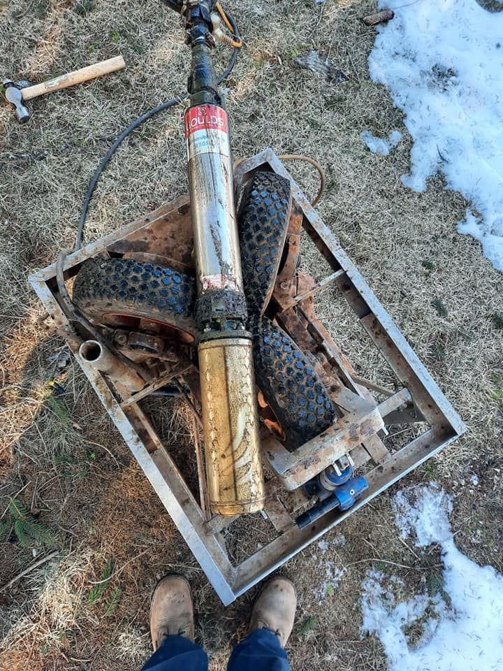 a person is standing next to a water pump in a wooden box .