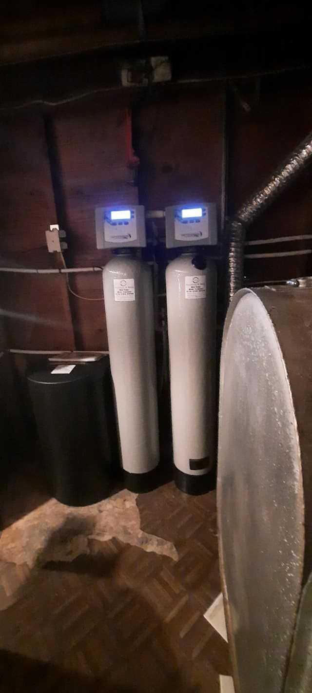 a couple of white tanks with a label that says ' water treatment ' on it