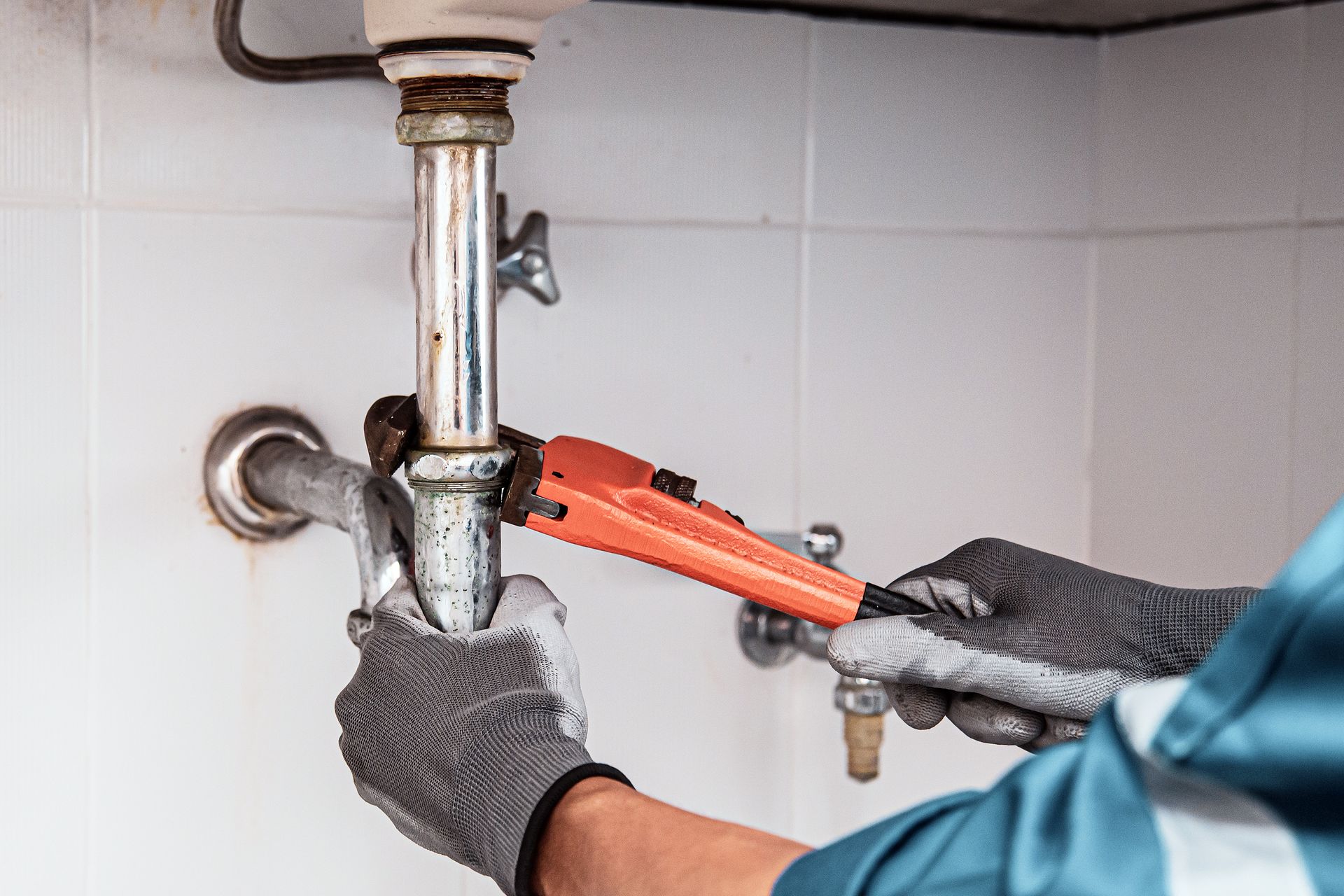 a plumber is fixing a pipe with a wrench