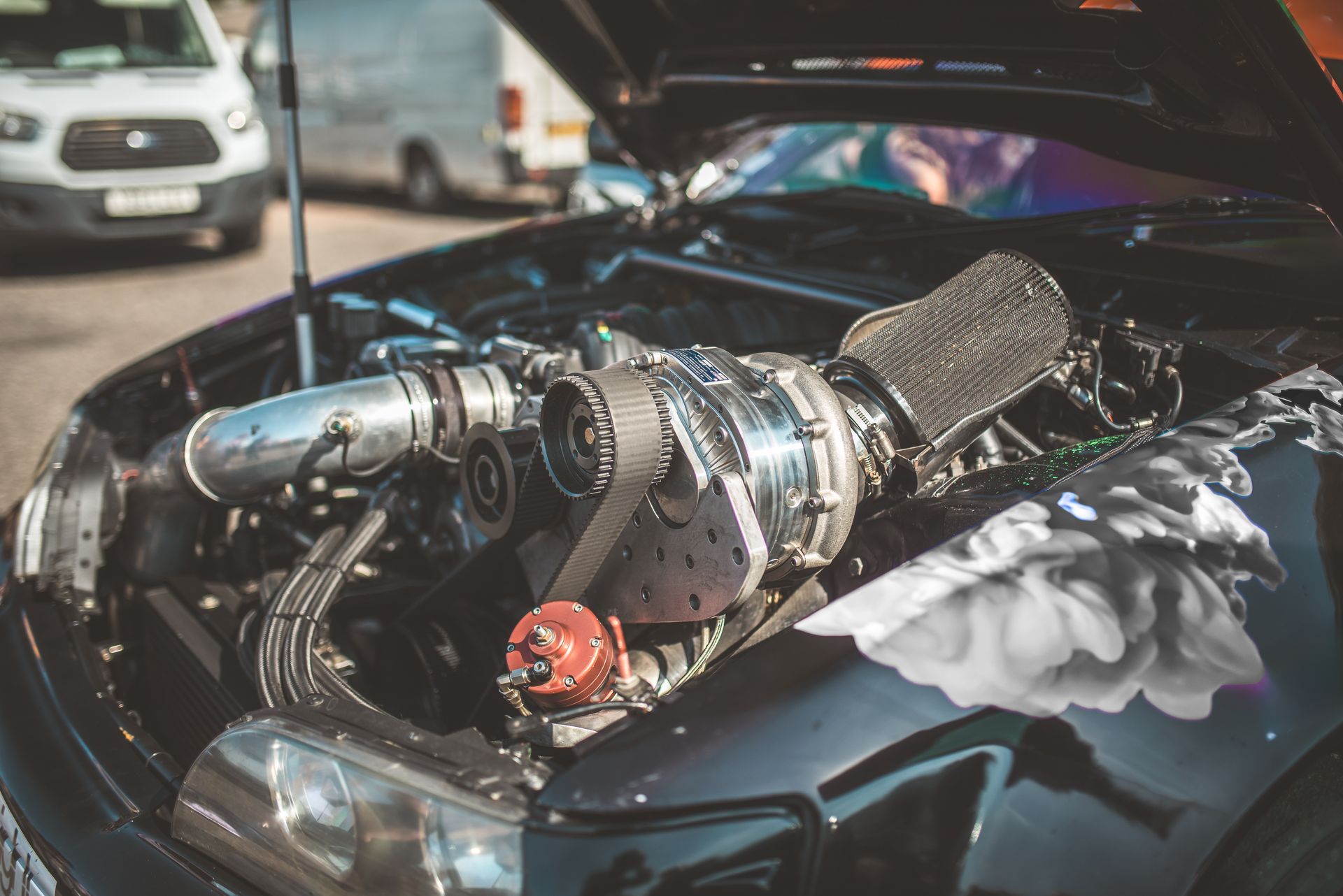 Close-up of a black car engine with a supercharger. 