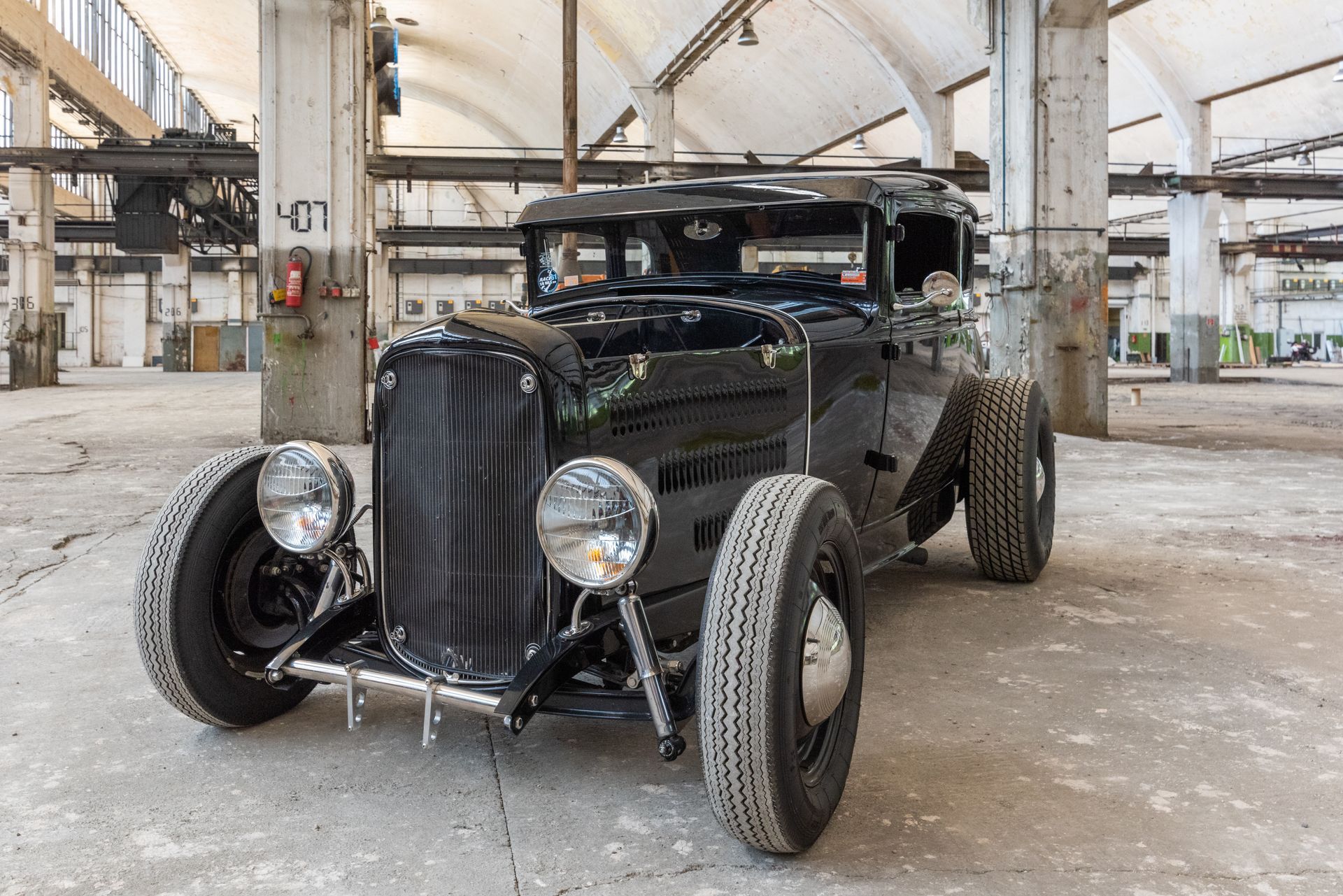Black vintage hot rod in a dilapidated industrial building.