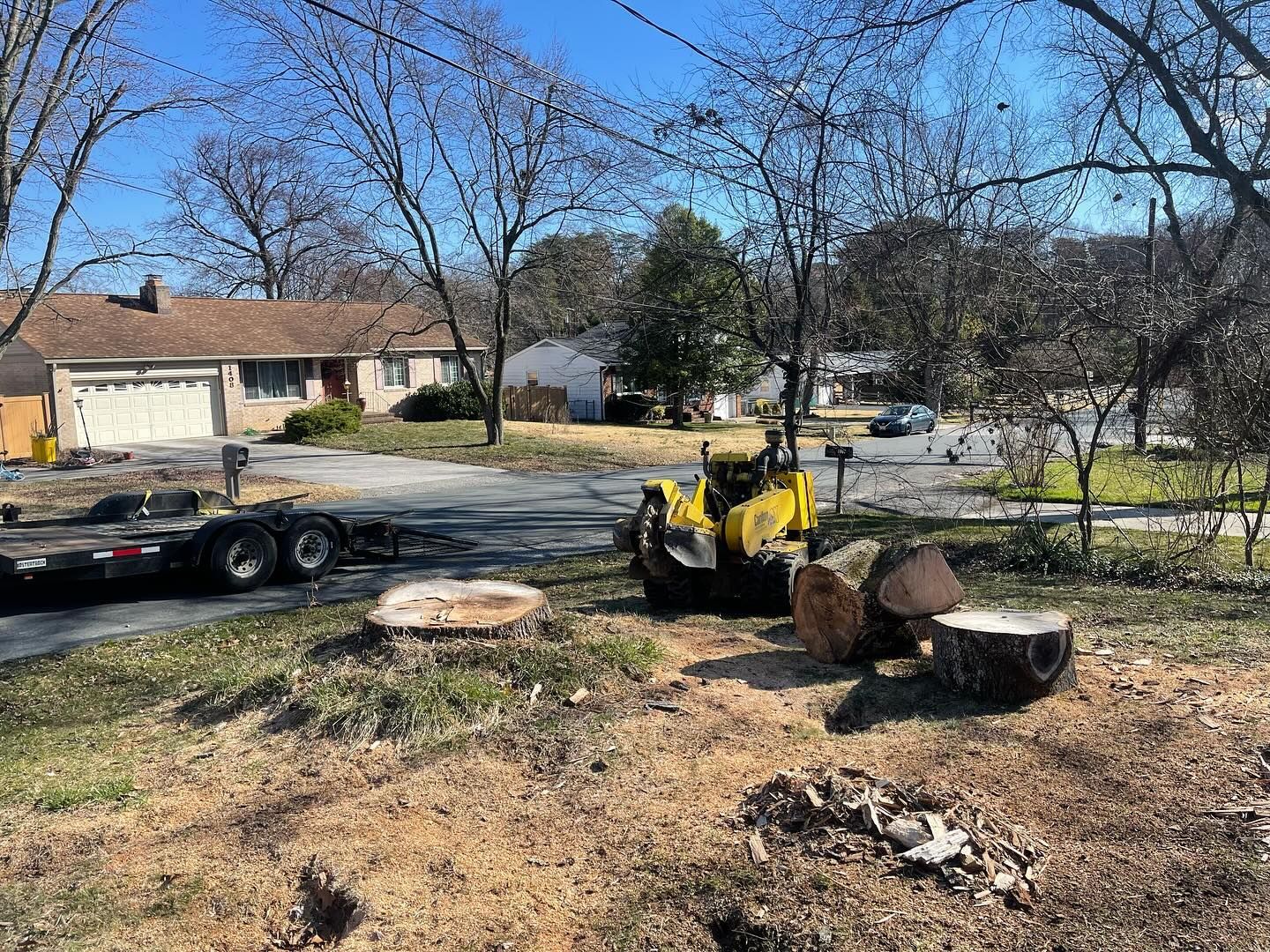 A yellow truck is driving down a road next to a tree stump.