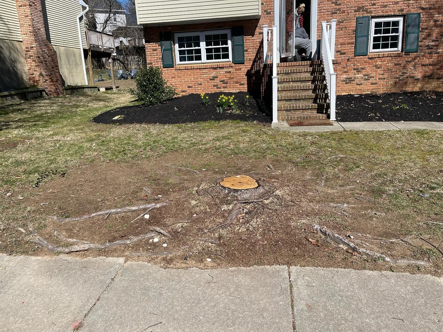 A brick house with a tree stump in front of it.