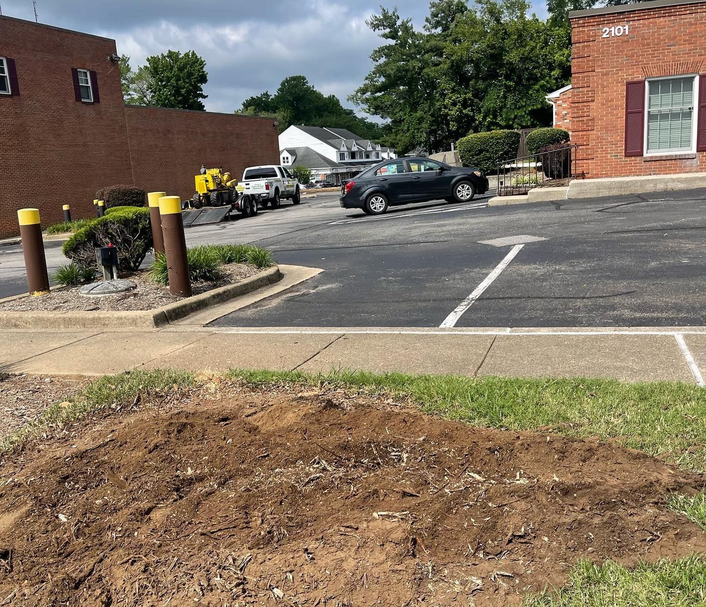 A parking lot with cars parked in front of a brick building.